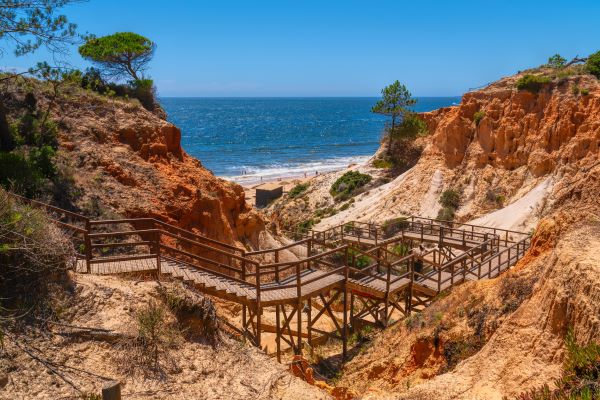 Holzstufen, die zum Praia da Falésia Strand in der Algarve, Portugal, hinabführen, mit Blick auf den schönen Sandstrand in der Nähe von Vilamoura und Albufeira