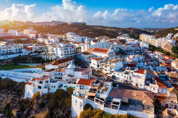  Luftaufnahme von Albufeira an der Algarve mit einem weiten Sandstrand und weißer Architektur.