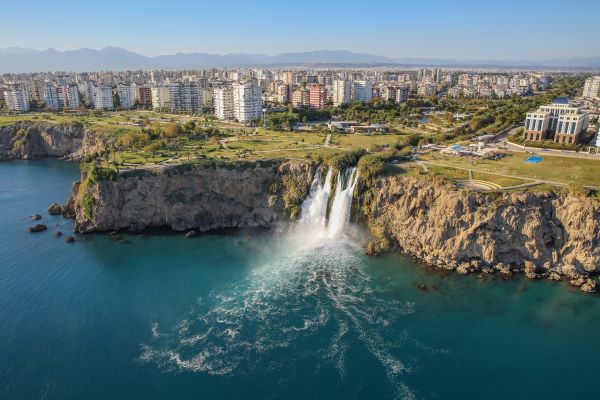 Blick auf den Düden-Wasserfall in Antalya, mit Wasser, das malerisch von den Klippen in einen klaren Teich stürzt, umgeben von grüner Vegetation